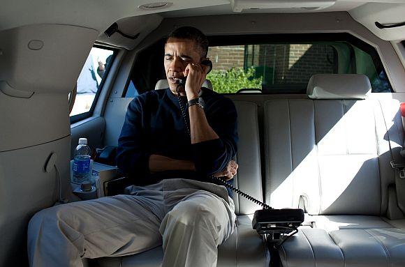 President Barack Obama talks on the phone with Afghanistan President Hamid Karzai from his vehicle to express his shock and sadness over the killing of Afghan civilians