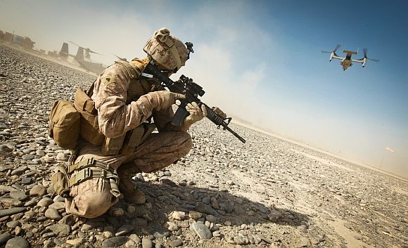 US Marine Corps Cpl William Cox, an armorer assigned to the Joint Sustainment Academy Southwest, holds an M4 carbine while providing security as an MV-22 Osprey takes off in support of Enduring Freedom in Zaranj, Nimroz province