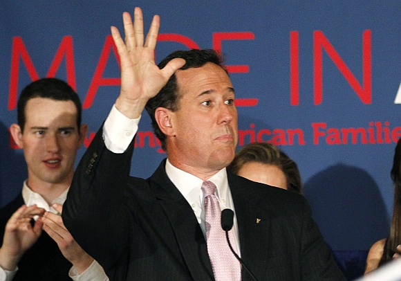 Santorum waves as he addresses supporters at his Alabama and Mississippi primary election night rally in Lafayette, Louisiana