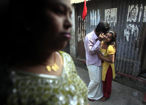 Seventeen-year-old Hashi talks to a customer as Maya waits to get a customer at Kandapara brothel in Tangail