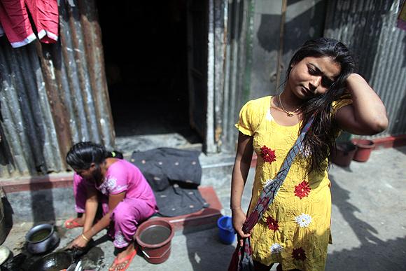 Seventeen-year-old prostitute Hashi stands in front of her small room at Kandapara brothel in Tangail, a northeastern city of Bangladesh