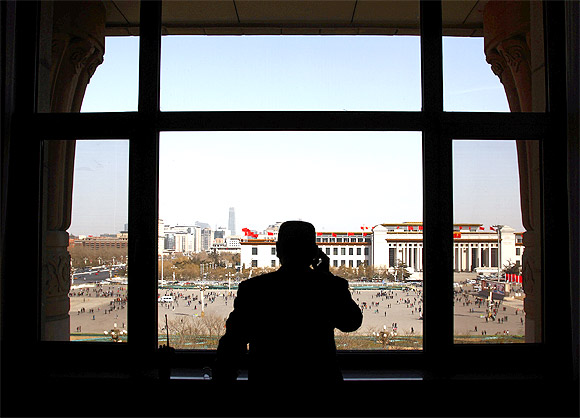 A security guard looks over Beijing's Tiananmen Square from inside the Great Hall of the People before the start of the meeting between the Tibetan provincial delegation and representatives from the National People's Congress in the Tibet Room