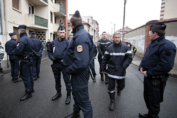 Police forces block a street during a raid on a house to arrest suspects in the killings of three children and a rabbi on Monday at a Jewish school, in Toulouse