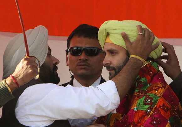 Rahul Gandhi is presented with a turban by his party supporters during a campaign rally ahead of assembly elections at Sirhind in Punjab