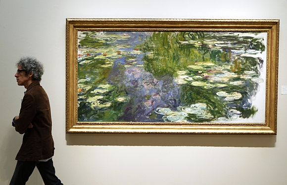A man walks past Le Bassin aux Nympheas during a preview of Sotheby's Impressionist & Modern Art auction in New York