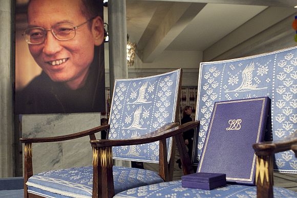 The Nobel certificate and medal is seen on the empty chair where 2010's Nobel Peace Prize winner jailed Chinese dissident Liu Xiaobo would have sat, as a portrait of Liu is seen in the background, during the ceremony at Oslo City Hall December 10, 2010