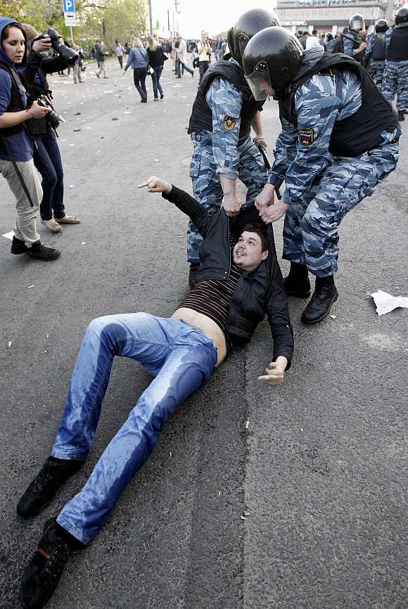 Russian riot police detain a protester during the