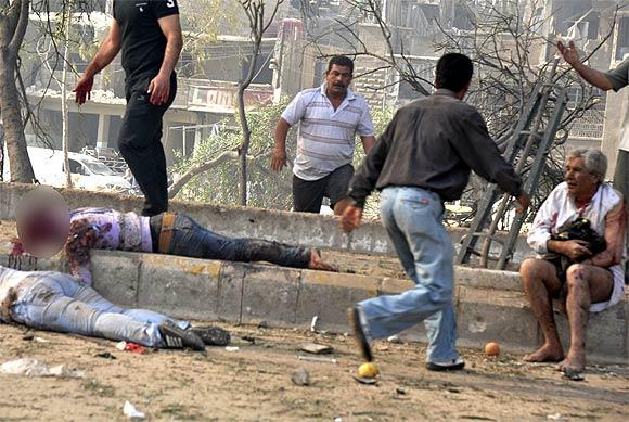 People run to help those wounded at the site of an explosion in Damascus