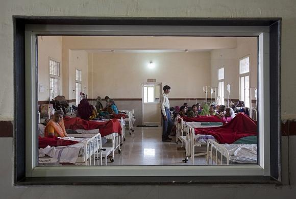 Women who have recently given birth and their relatives are pictured through a nurse's observaton window as they rest in a post delivery ward at a district hospital in Shivpuri, Madhya Pradesh