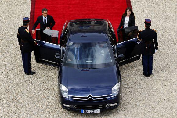 France's outgoing President Nicolas Sarkozy and outgoing First Lady Carla Bruni-Sarkozy leave the Elysee Palace at the end of a handover ceremony in Paris on Tuesday