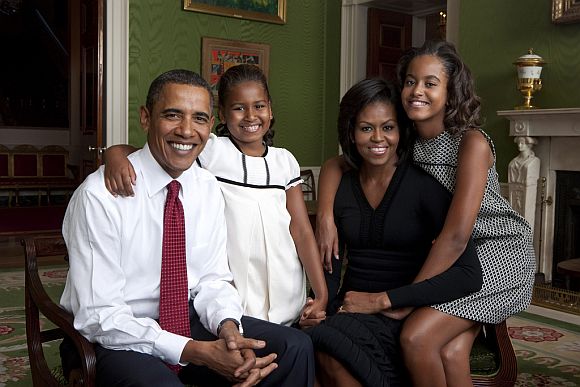 President Barack Obama, First Lady Michelle Obama, and their daughters, Sasha and Malia, sit for a family portrait in the Green Room of the White House