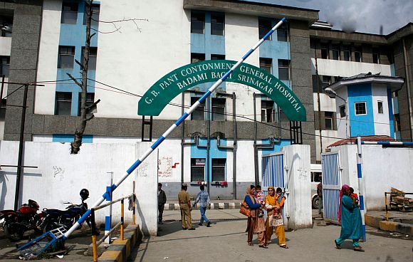 Women carrying their children are seen walking out of the G B Pant hospital in Srinagar, where 400 baby deaths have been reported in the past 5 months