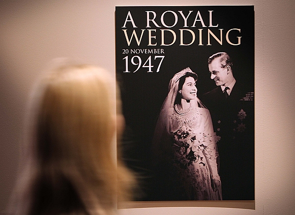 A worker looks at a poster of the 'Royal Wedding: 20 Novermber 1957 exhibition' at Buckingham Palace on July 27, 2007 in London. Queen Elizabeth II will be the first reigning sovereign to celebrate a 60th wedding anniversary