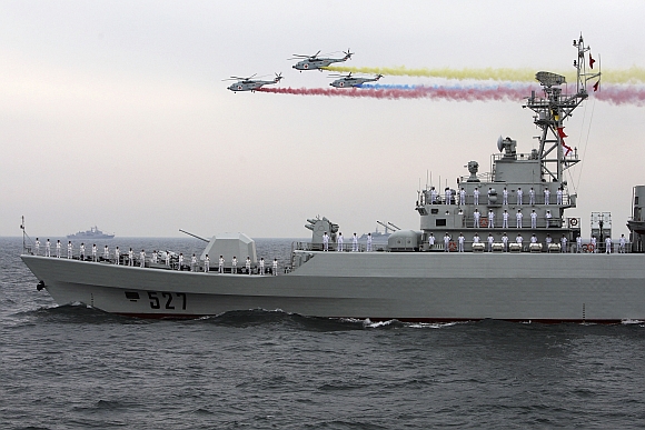 Helicopters fly past the Chinese Jiangwei II class naval frigate Luoyang at an international fleet review to celebrate the 60th anniversary of the founding of the People's Liberation Army Navy in Qingdao, Shandong province