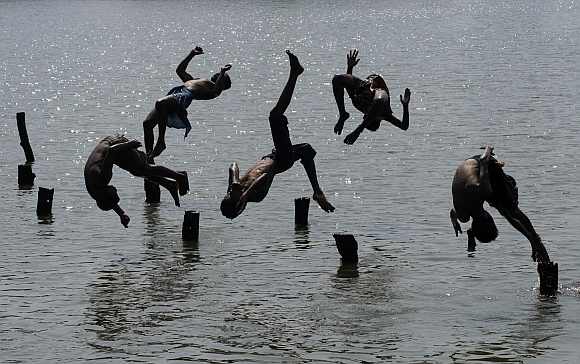 Boys jump in a pond to cool off in Agartala
