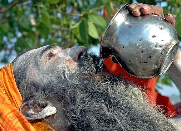A sadhu drinks water to beat the heat in Allahabad