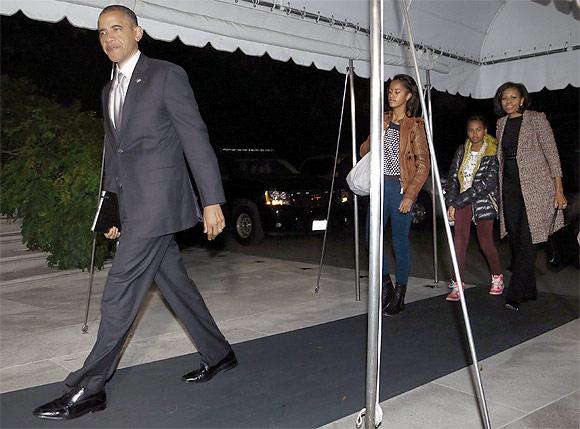 US President Barack Obama, his wife Michelle and their daughters Malia and Sasha return to the White House