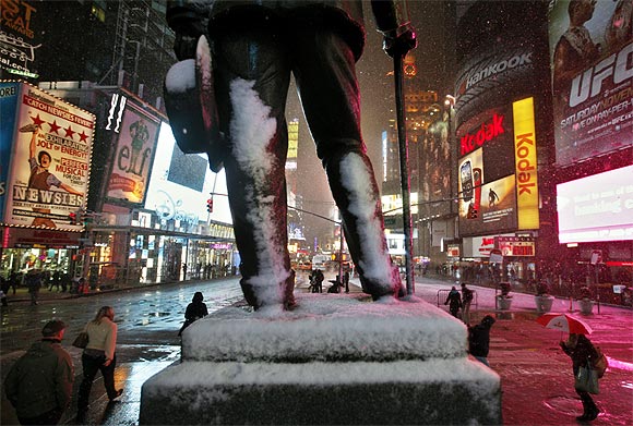 Snow gathers on the statue of George M Cohan in New York's Times Square