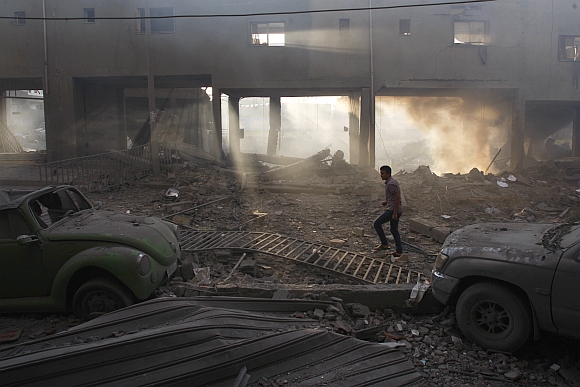 A Palestinian inspects the damage to a soccer stadium after an Israeli air strike in Gaza City