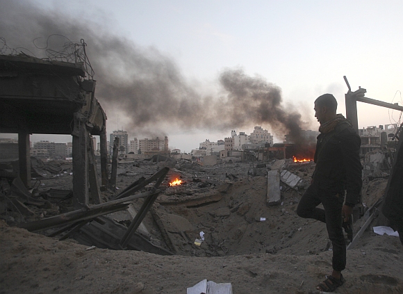 A Palestinian walks past a destroyed Hamas security site after an Israeli air strike in Gaza City