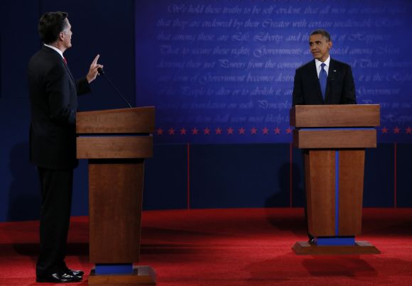 Republican presidential nominee Romney speaks as President Obama listens during the first presidential debate in Denver