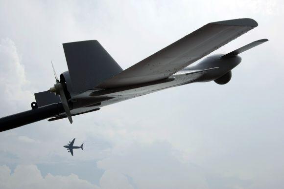 A Boeing C-17 Globemaster III military transport aircraft of the United States Air Force (USAF) flies past a Harop unmanned combat air vehicle (UCAV) during an aerial display at the Singapore Airshow in Singapore