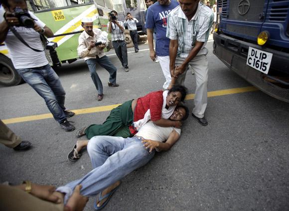 An activist of India Against Corruption, part of the anti-corruption social activist group led by Arvind Kejriwal, is being detained by police during a protest march in New Delhi