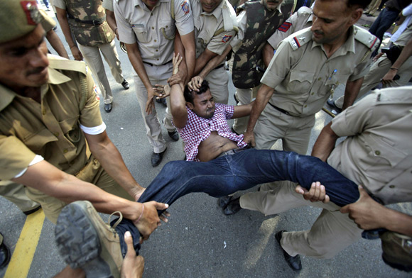 An IAC activist is being detained by police during a protest march in New Delhi