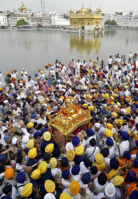 Sikh devotees carry the Guru Granth Sahib in a palanquin during a religious procession inside the Golden Temple.