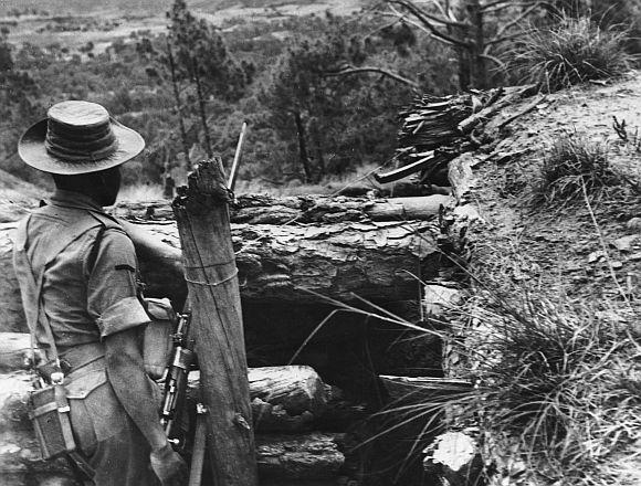 An Indian soldier stands guard over makeshift forts which have been hastily built in Ladakh during the India-China war in 1962