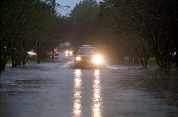 Vehicles make their way through flooded streets as the effects of wind and rain from Hurricane Sandy hit Virginia Beach, Virginia,