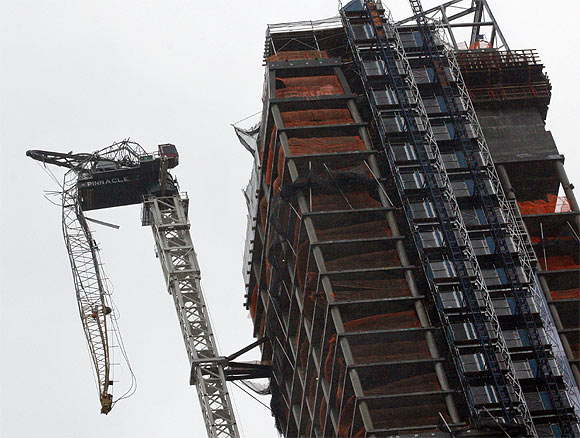 partially collapsed crane hangs from a high-rise building in Manhattan as Hurricane Sandy makes its approach in New York