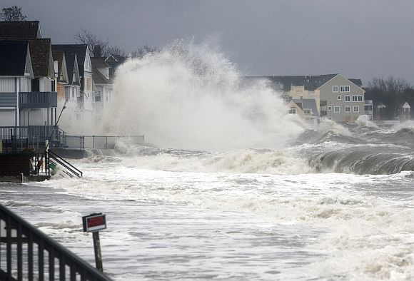 Waves crash over homes along the shoreline in Milford, Connecticut