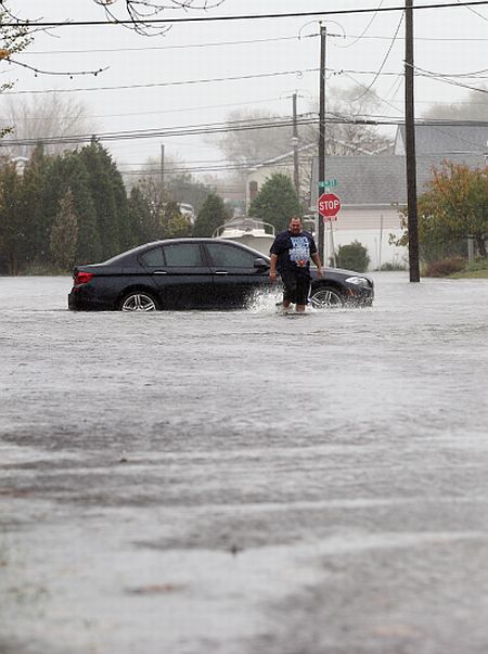 Joseph Arpaio of Massapequa abondons his car on 5th Street as high tide, rain and winds flood local streets in Lindenhurst, New York