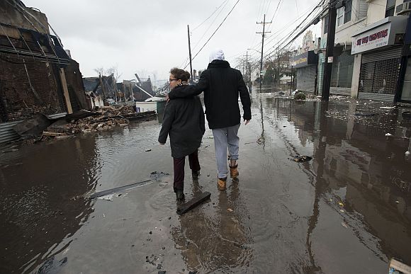 People walk through floodwaters in the Rockaways section of New York