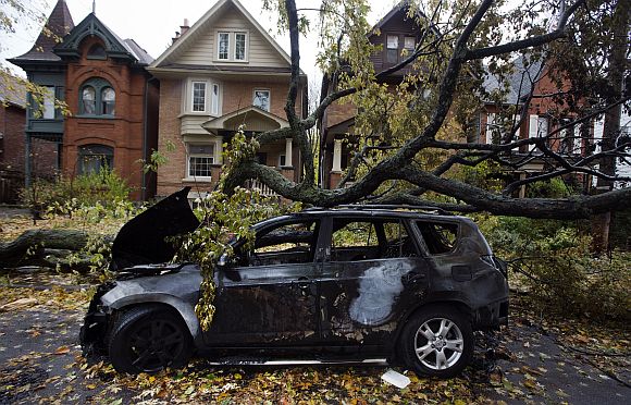 A car is seen burned out in an electrical fire after a tree fell over a power line due to the remnants of Hurricane Sandy in Toronto