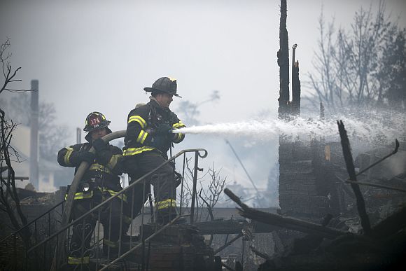 Firefighters work to extinguish a fire in the Rockaways section of New York