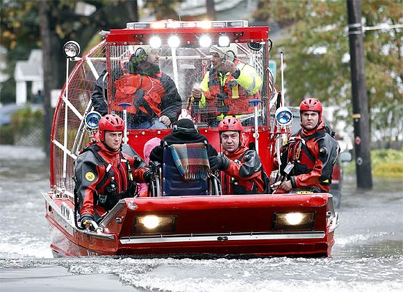 Rescue workers use a hovercraft to rescue a wheelchair-bound resident from flood waters brought on by Hurricane Sandy
