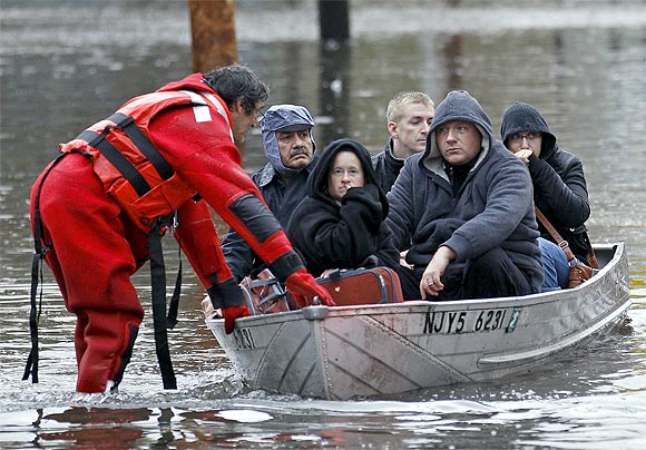 Residents are rescued by emergency personnel from flood waters brought on by Hurricane Sandy