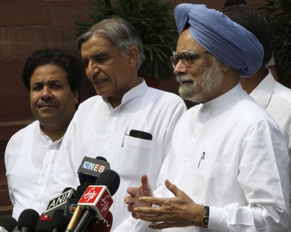 Prime Minister Singh speaks to the media as Minister of State for Parliamentary Affairs Shukla and Parliamentary Affairs Minister Bansal watch