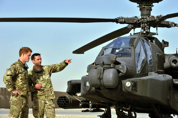 Britain's Prince Harry is shown the Apache helicopter flight line by an unidentified member of his squadron at Camp Bastion, Afghanistan