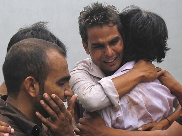 Relatives mourn their loved ones, who were killed in a fire at a garment factory, after their bodies were brought to the Jinnah hospital morgue in Karachi