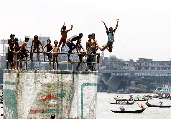 Children jump into Buriganga River to cool themselves in Dhaka
