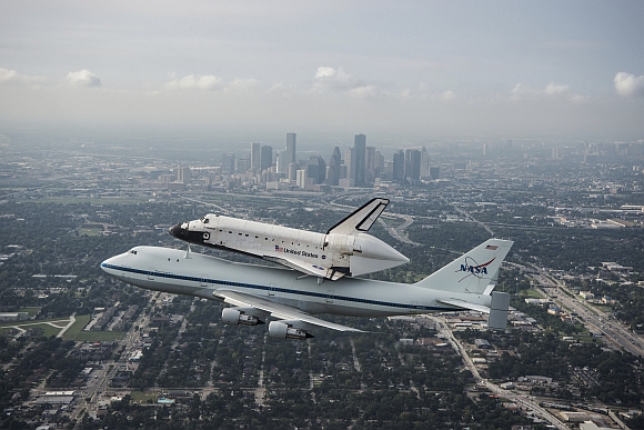 The space shuttle Endeavour, atop NASA's Shuttle Carrier Aircraft, flies over Houston, Texas