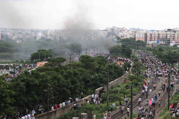 Smoke is seen as activists gather near Necklace Road in Hyderabad for a protest march