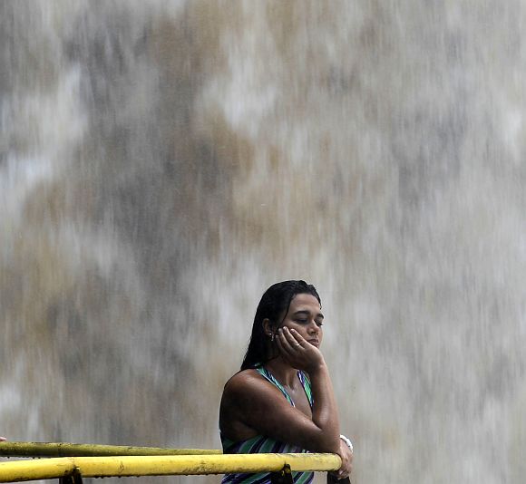 A tourist watches the Iguazu Falls from a viewing point on the border of Argentina's province of Misiones and Brazil's State of Parana