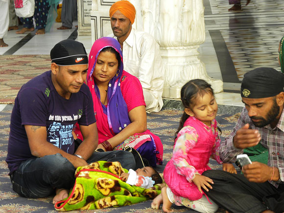A Punjabi family relaxes in front of the Harmandir Sahib