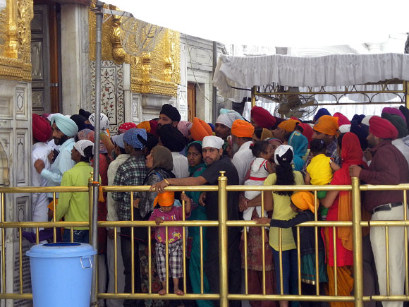 Crowds peacefully queue up, with very little jostling, early morning  to enter the Harmandir Sahib where the the holy Guru Granth Sahib is placed