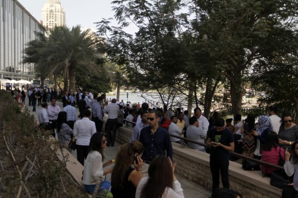 People wait outside after evacuating offices in Dubai Media City following earthquake tremors on Tuesday.