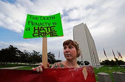 An anti-death penalty protester holds a placard during a rally and a march in front of the Federal Building in Los Angeles